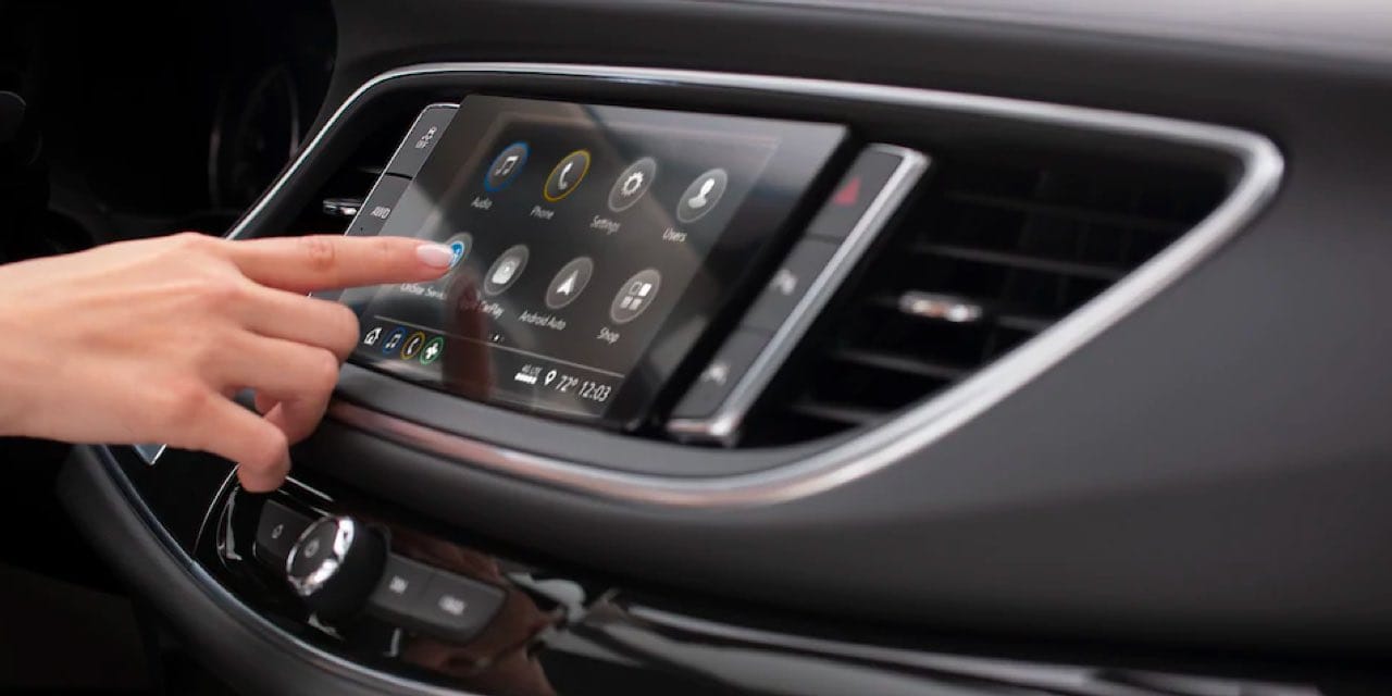 Buick Enclave Interior, driver using touchsreen display.