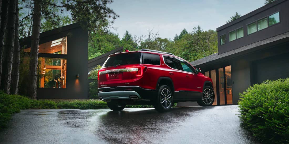 A rearview of a red Acadia parked on a driveway