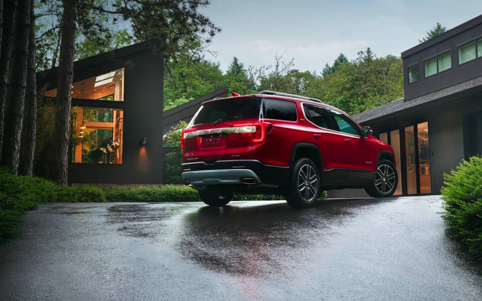 A rear view of a red Acadia parked on a driveway 