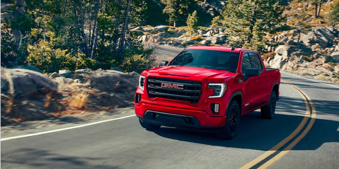 Cardinal red GMC Sierra 1500 turning through a mountainside