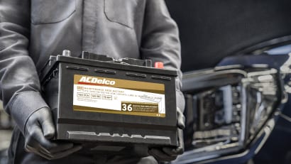 GM technician carrying an AC Delco replacement battery
