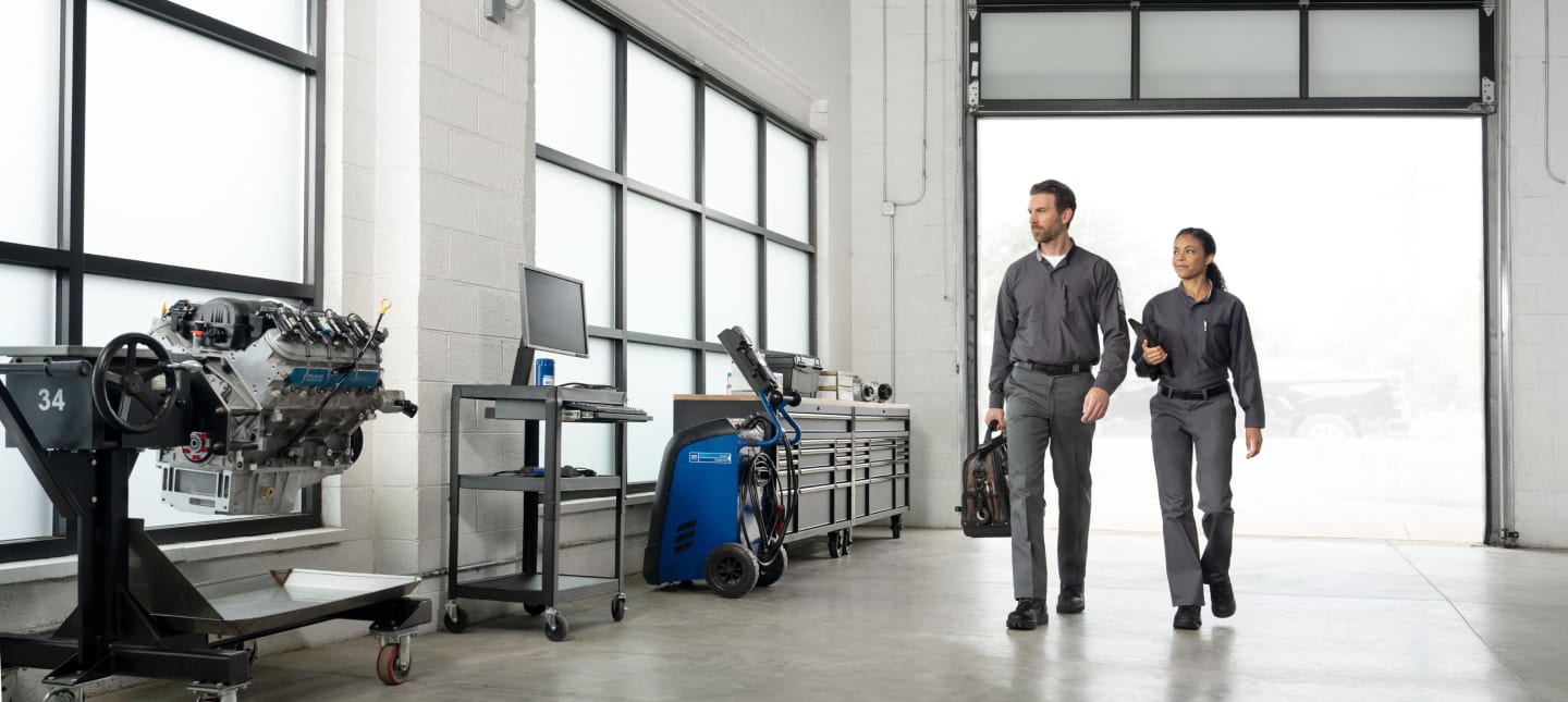 2 GM technicians walking in a service bay